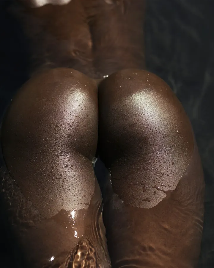 Femme africaine en lingerie jaune, allongée sur le côté, regardant l'appareil