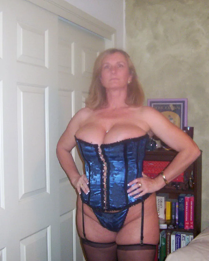Femme aux cheveux blonds, portant une robe noire, bijoux, cheveux blonds courts, en soirée.