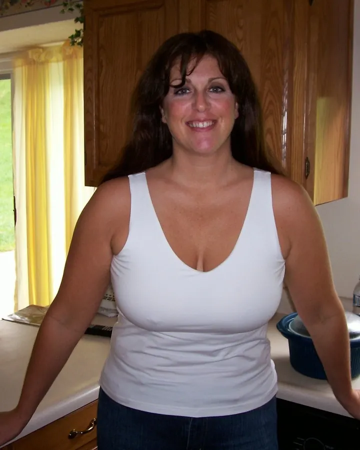 Femme aux cheveux noirs portant un soutien-gorge noir, tenant son doigt sur les lèvres, avec un collier en verre transparent.