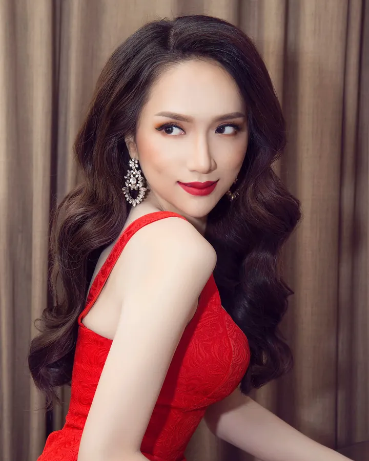 femme asiatique en robe rouge et boucles d'oreilles, regard sur le côté