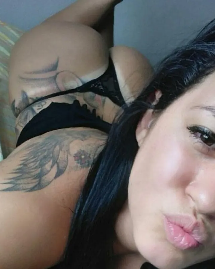 Femme aux cheveux noirs, prenant un selfie dans un miroir, nue, portant un bandeau rayé.